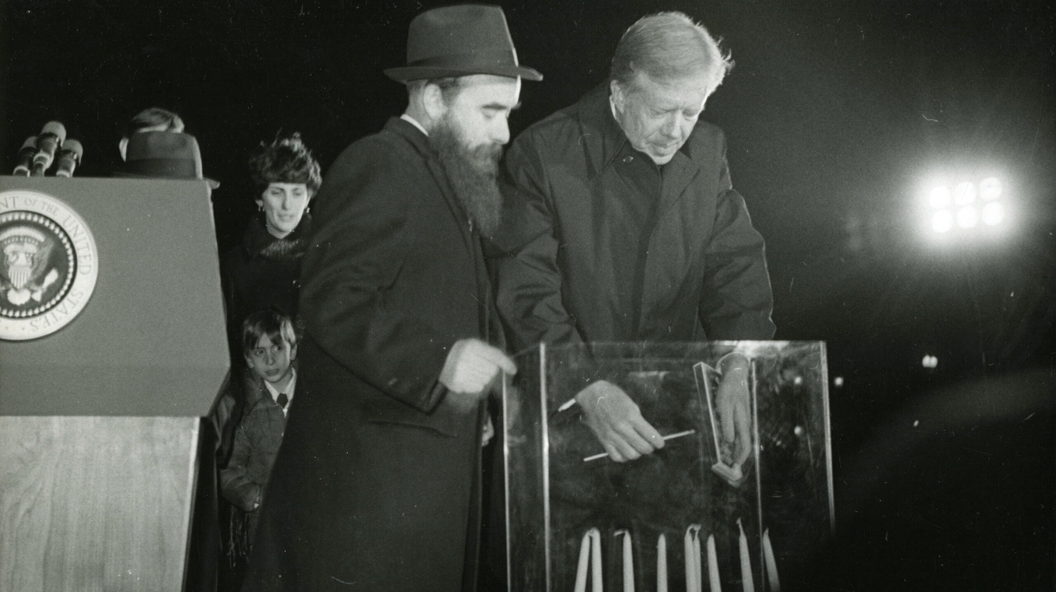 Accompanied by Rabbi Abraham Shemtov, President Jimmy Carter lights the first menorah in Lafayette Square across from the White House, Dec. 17, 1979. (Capital Jewish Museum Collection. Gift of the Washington Jewish Week.)