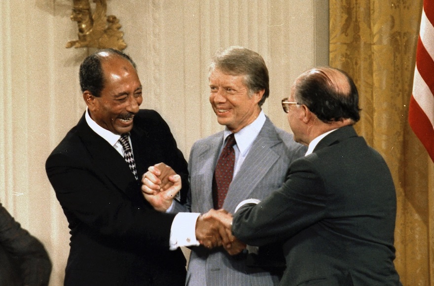 Three men shake hands