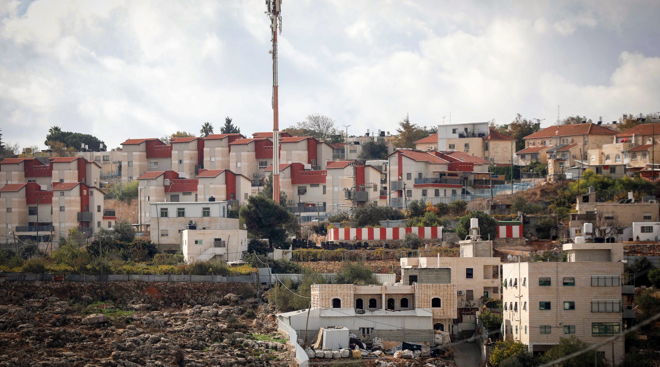 limestone apartment blocks with red roofs on a sloping landscape