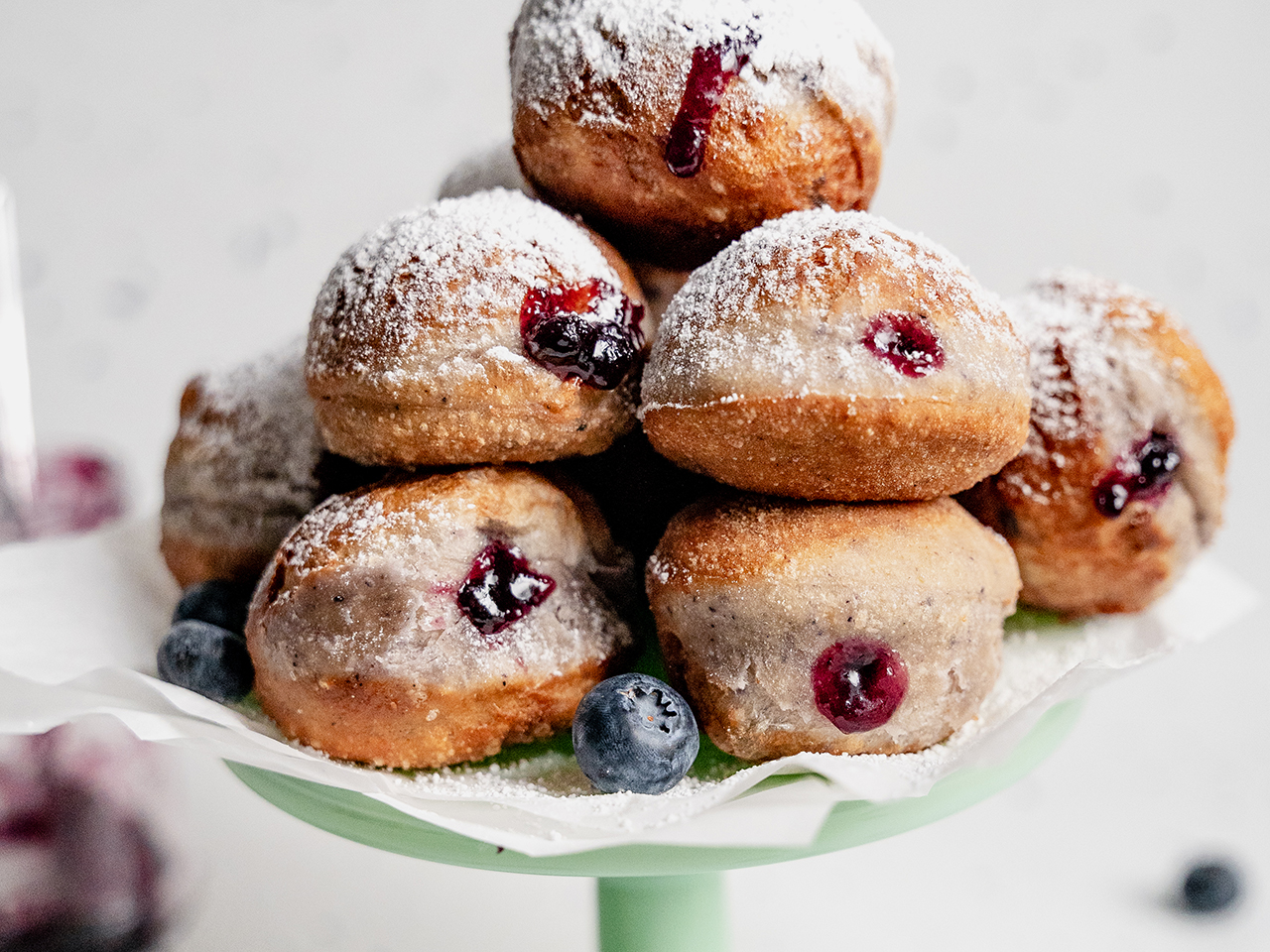 a pile of jelly donuts dusted with powdered sugar