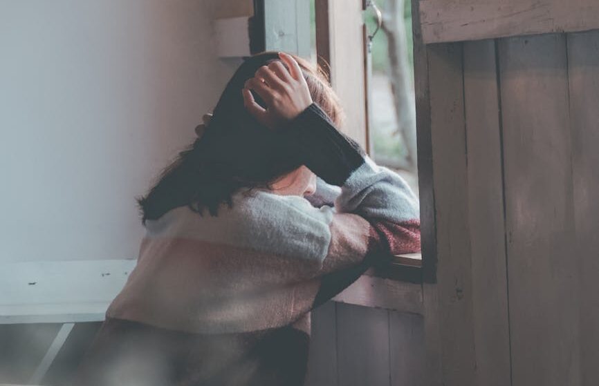 photo of a person leaning on wooden window