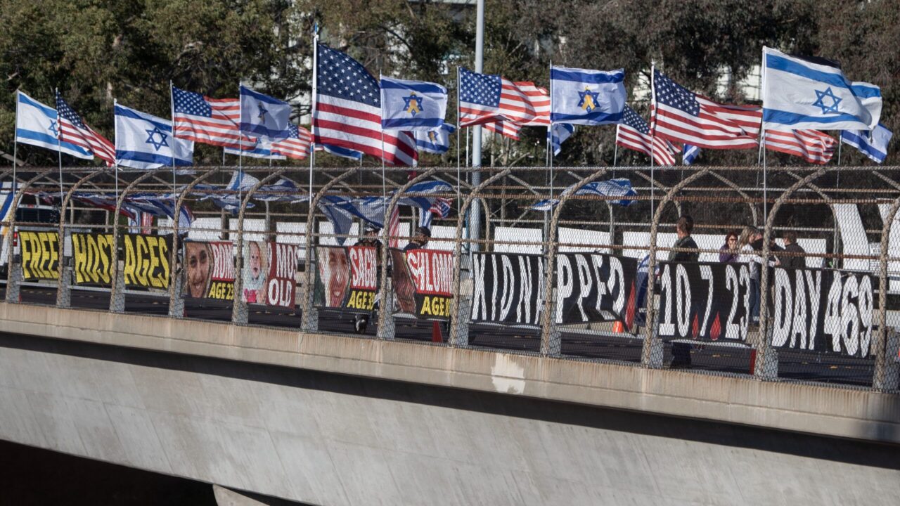 U.S. and Israeli flags flutter in the wind during a Jan. 17 vigil above Highway 24 in support of the hostages held by Hamas. (Aaron Levy-Wolins/J. Staff)