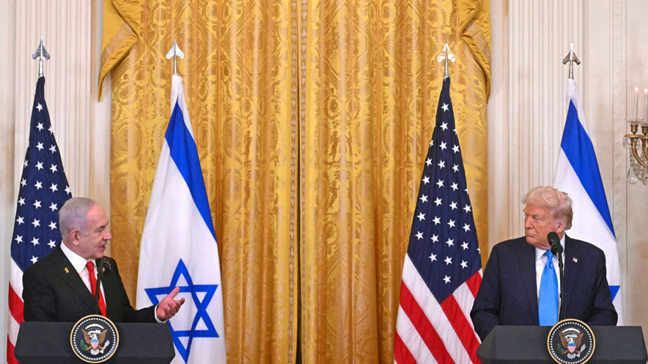 Netanyahu and Trump stand next to each other at lecterns with Israeli and US flags behind them