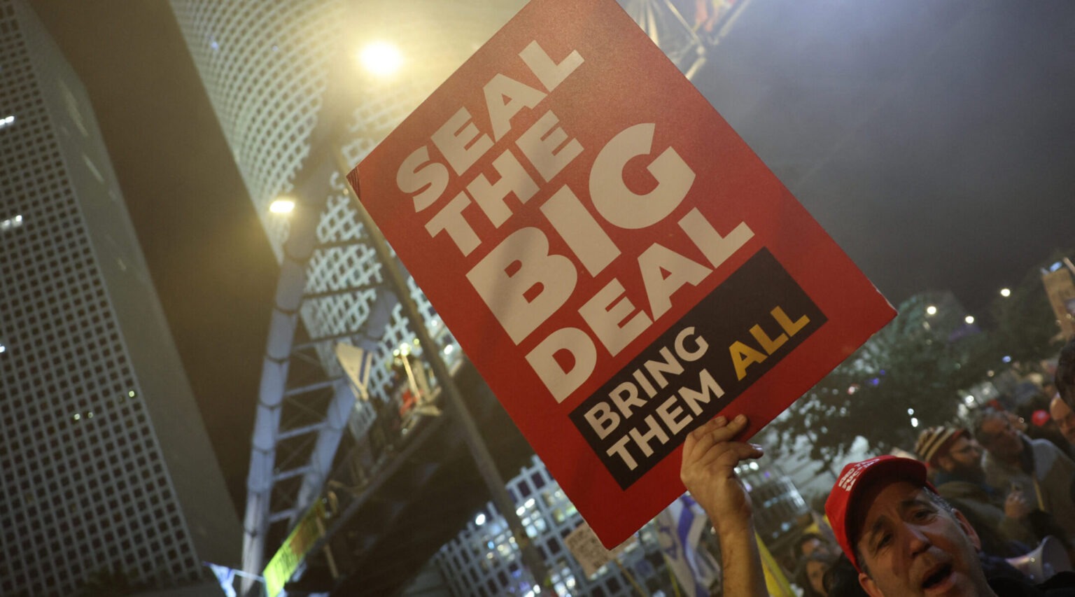 A man holds up a sign that says "Save the big deal. Bring them all."