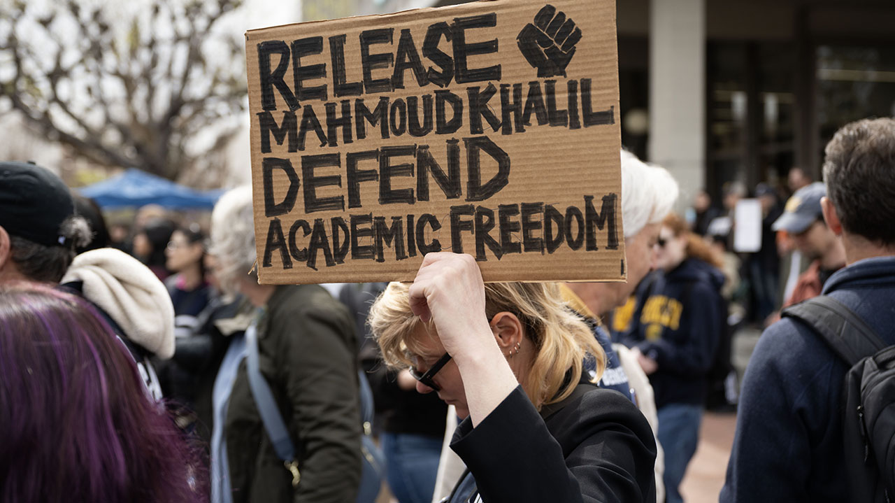 The sign reads "Release Mahmoud Khalil, Defend Academic Freedom"