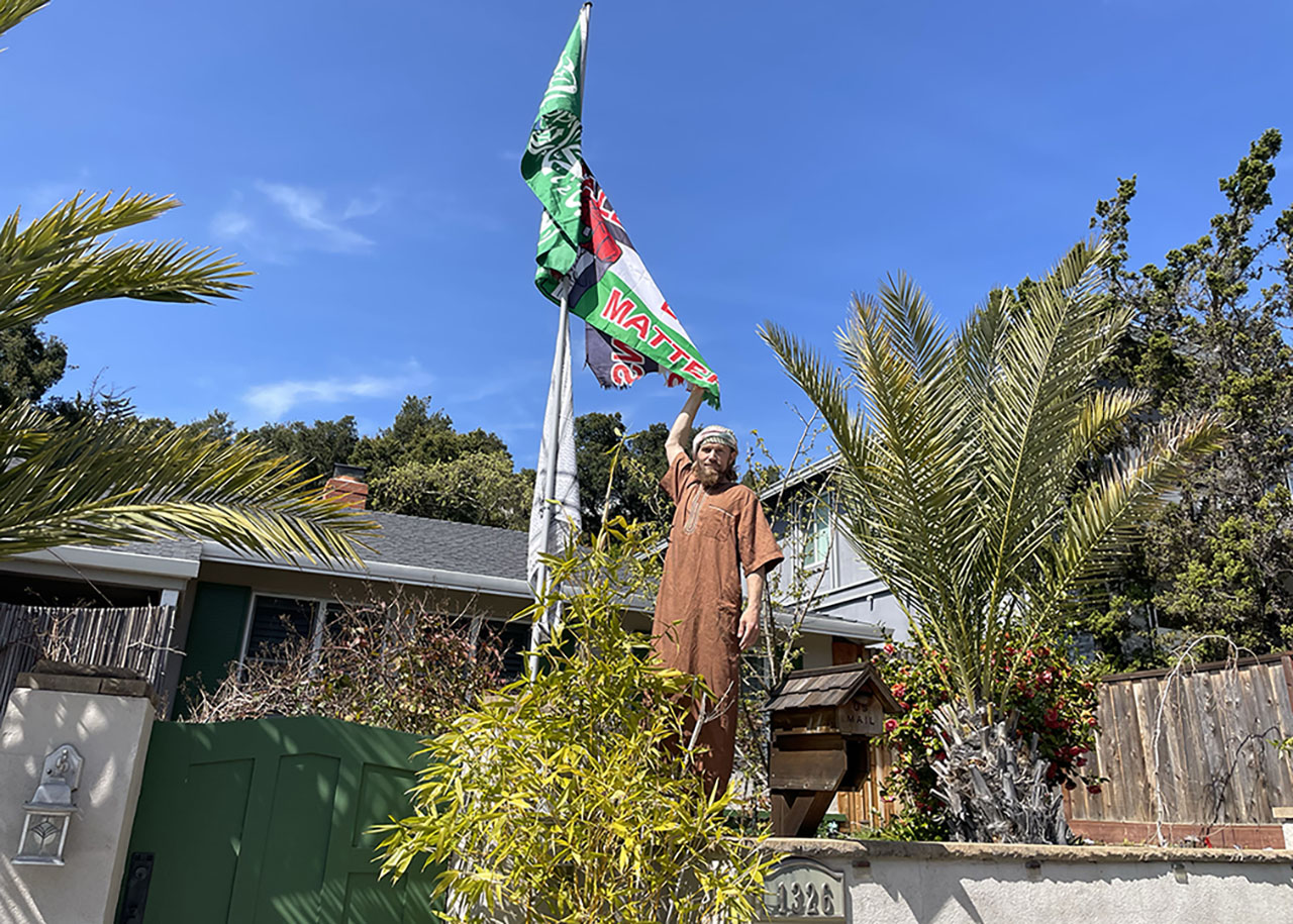 Rashid, who did not give his last name, stands next to a flagpole flying a Hamas flag, a Palestinian flag overlaid with “Palestinians Lives Matter” and a kaffiyeh outside his home in San Carlos on March 20, 2025. (Emma Goss/J. Staff)
