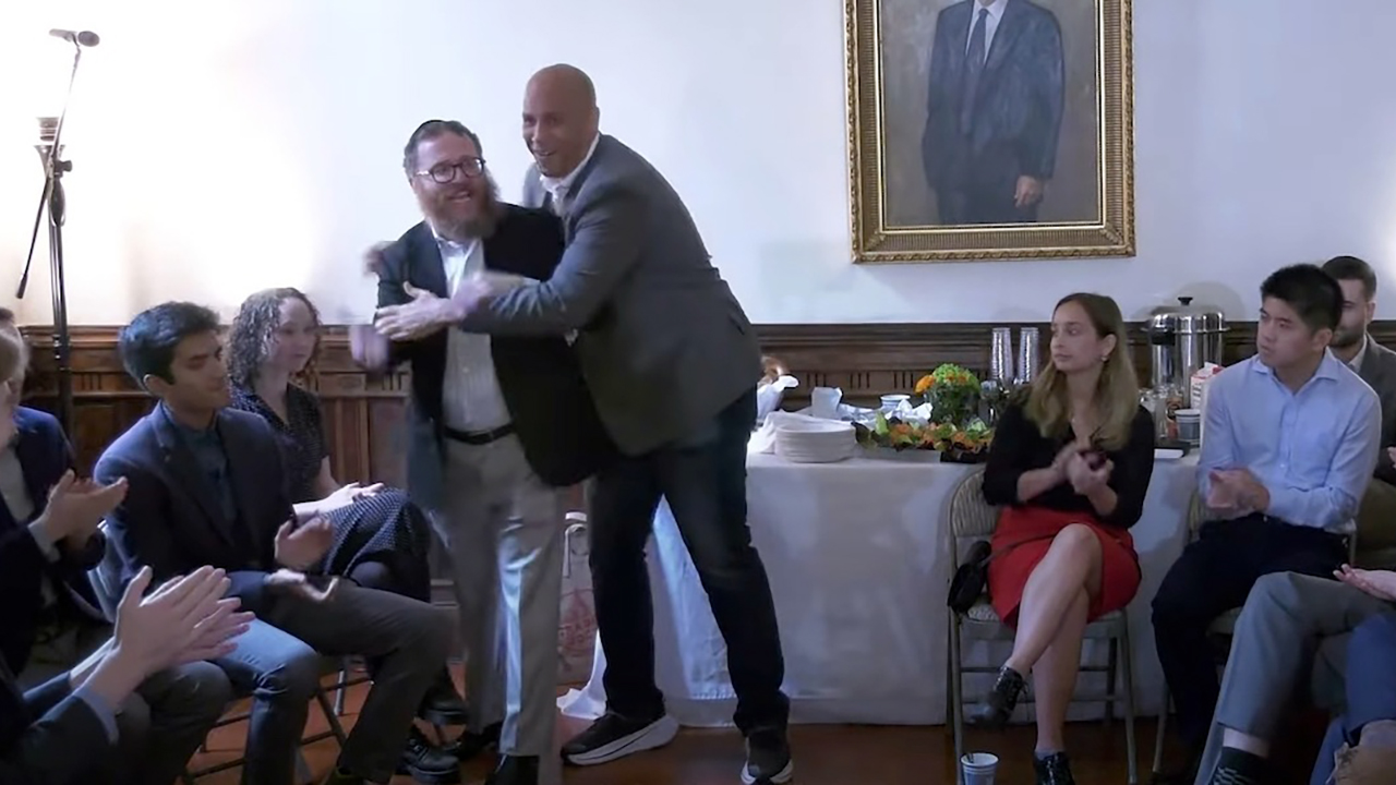 New Jersey Sen. Cory Booker (D) hugs Rabbi Shmully Hecht at an event for Shabtai, a Jewish society at Yale University, Oct. 25, 2022, in New Haven, Connecticut. Booker co-founded the organization with Hecht. (Screenshot via YouTube)