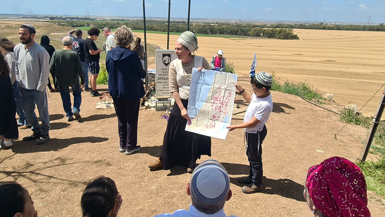 Arbel Zak, a senior Nachala leader, holds a map of envisioned settlements inside Gaza, at the Nachal Oz soldiers memorial overlooking Gaza, April 15, 2025. (Deborah Danan)