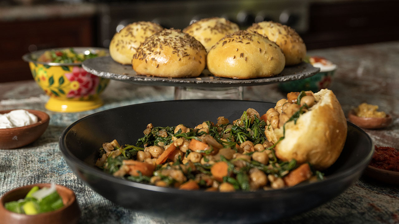 Faith Kramer’s Tunisian-inspired stew of chickpeas and greens, served with labneh, harissa and caraway seed challah rolls. (Aaron Levy-Wolins/J. Staff)
