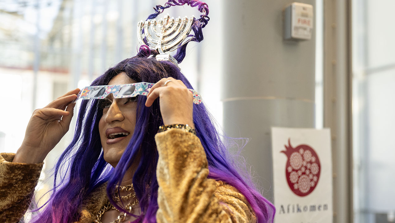 Miss Gefilte Fish, also known as Noah Zweben, tries on polarized glasses that make lights look like Stars of David during Value Culture’s Jewish American Heritage Month kickoff event at the California Academy of Sciences, May 15, 2025. (Aaron Levy-Wolins/J. Staff)