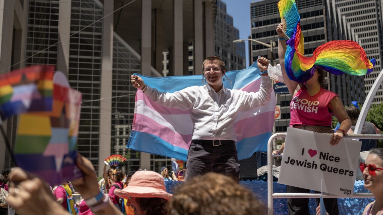Matt Lacoff holds aloft a trans pride flag behind him on the Jewish community's float at S.F. Pride in 2025. (Aaron Levy-Wolins/J. Staff)