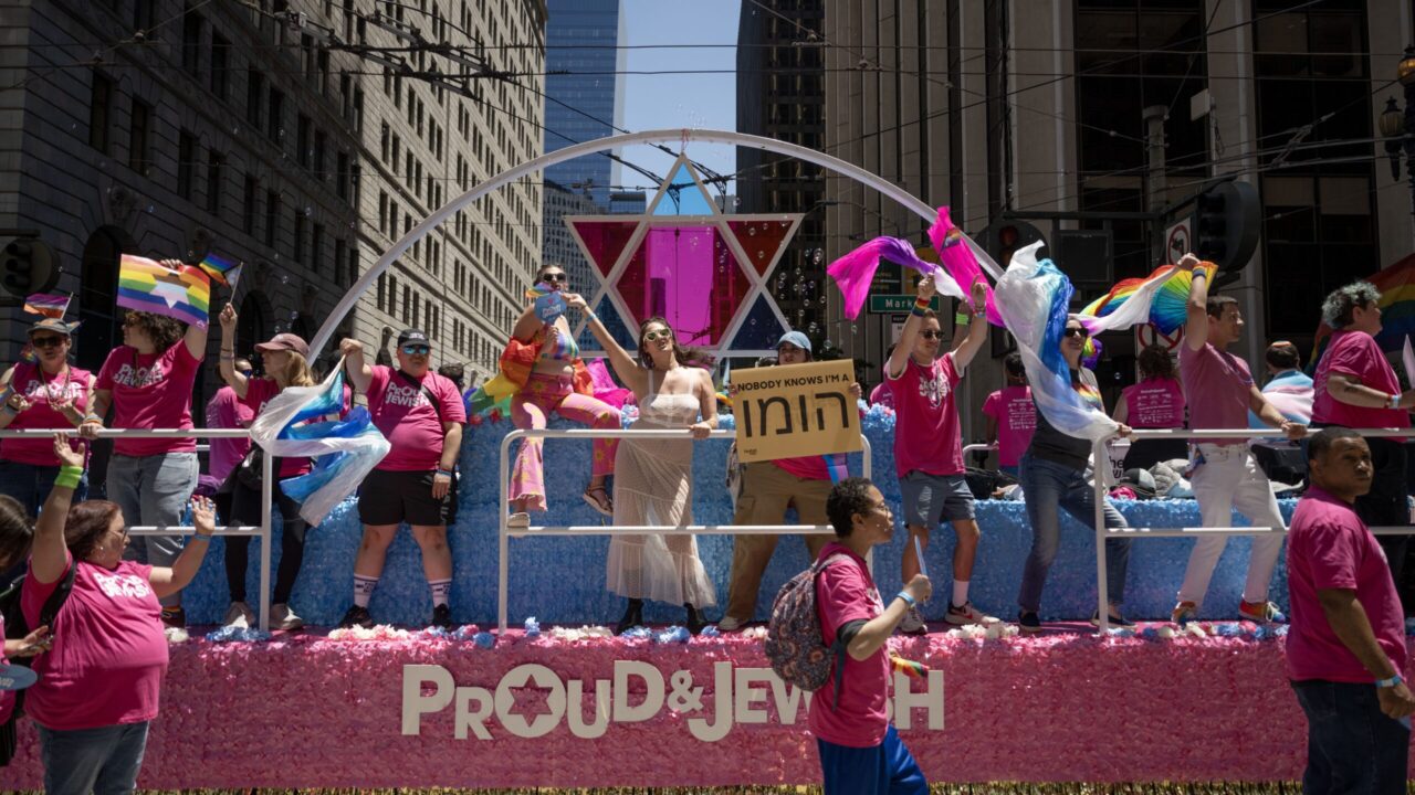 People dance on the Jewish community’s float during the San Francisco Pride Parade on Sunday. And someone with a great sense of humor holds a sign stating: “Nobody knows I'm a homo,” written in Hebrish. (Aaron Levy-Wolins/J. Staff)