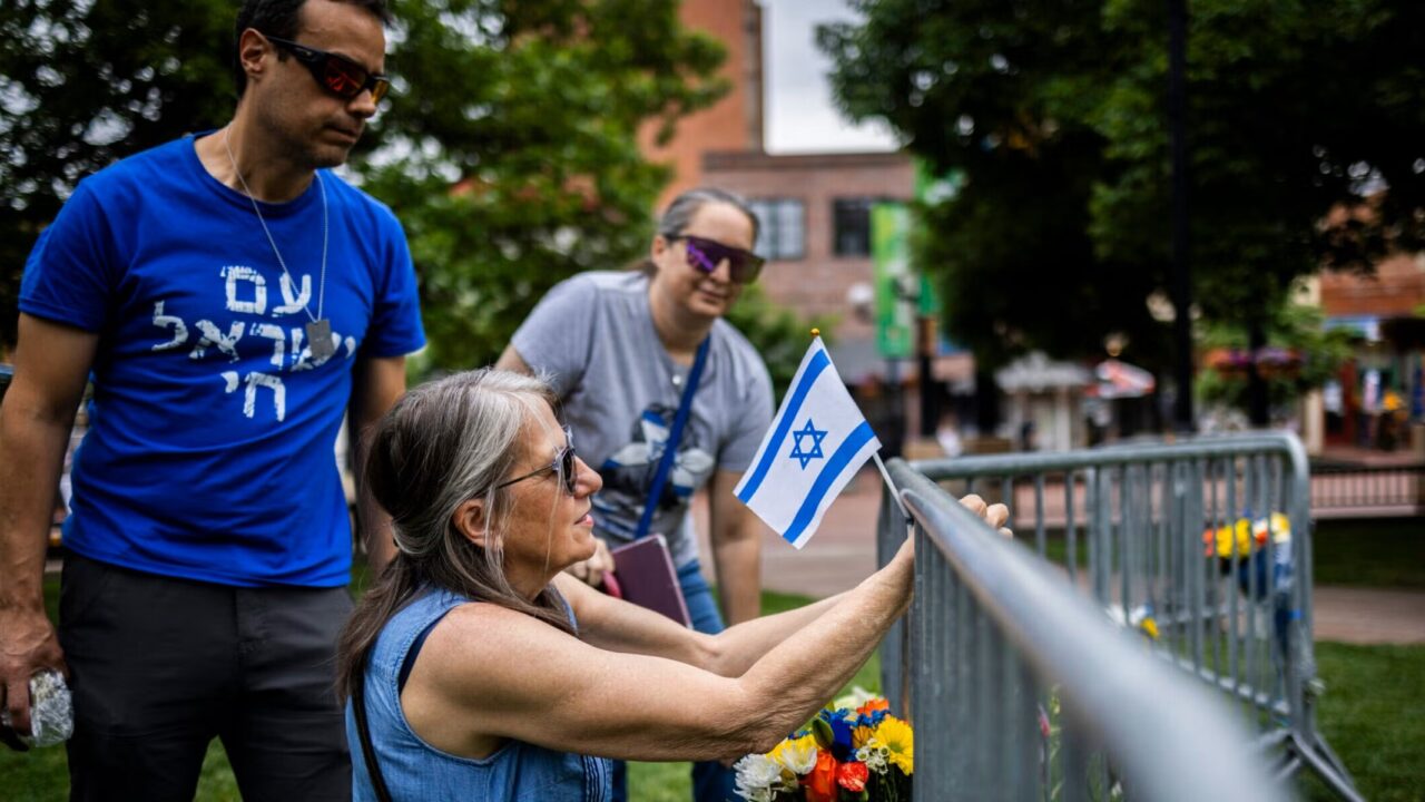 Lisa Turnquist of Louisville, Colorado, lays flowers and a flag at the site of the attack outside the Boulder County Courthouse on June 2, 2025, in Boulder. (Chet Strange/Getty Images)