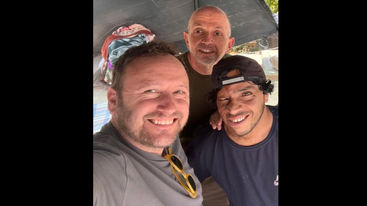 three men stand together