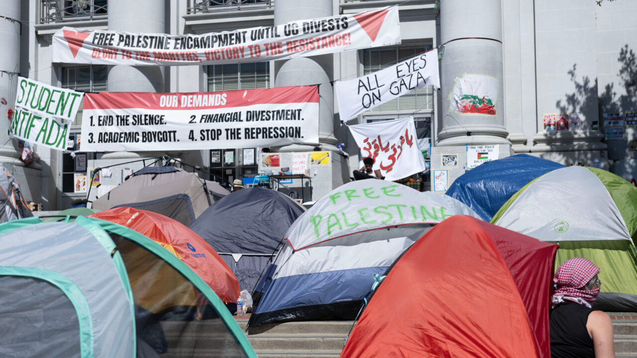 Pro-Palestinian protesters setting up tents and banners outside Sproul Hall at UC Berkeley.
