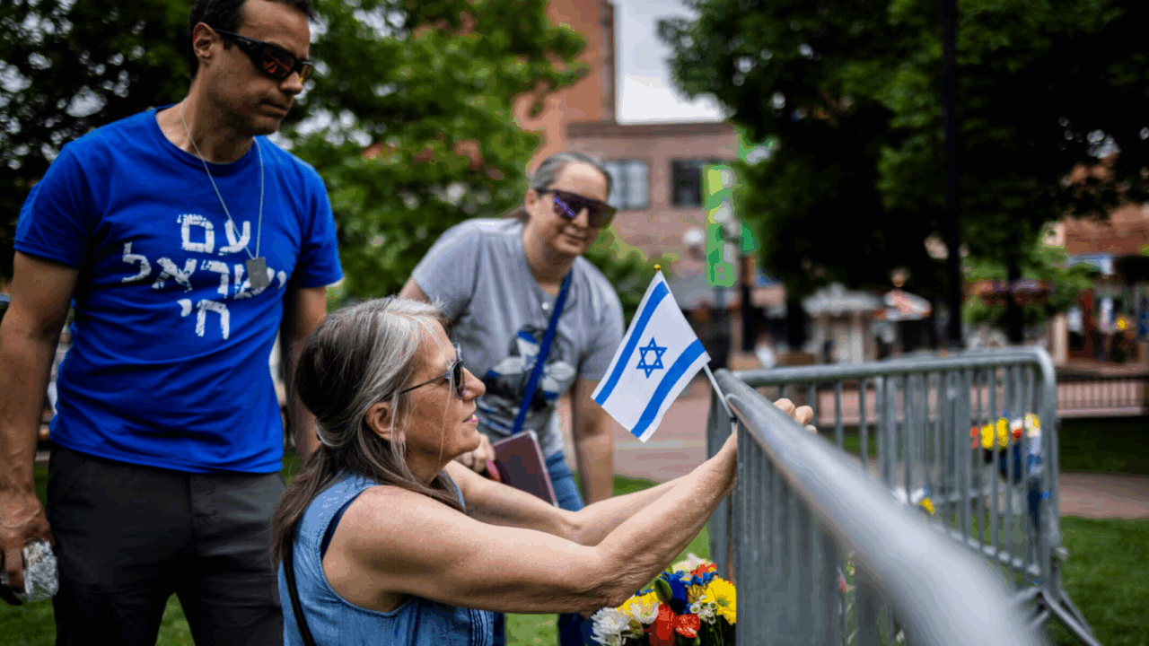 Activist lays flowers and a flag at site of attack