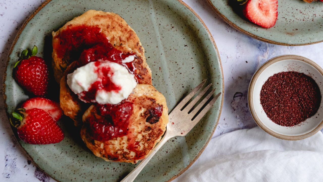 Syrniki pancakes with sumac strawberry topping