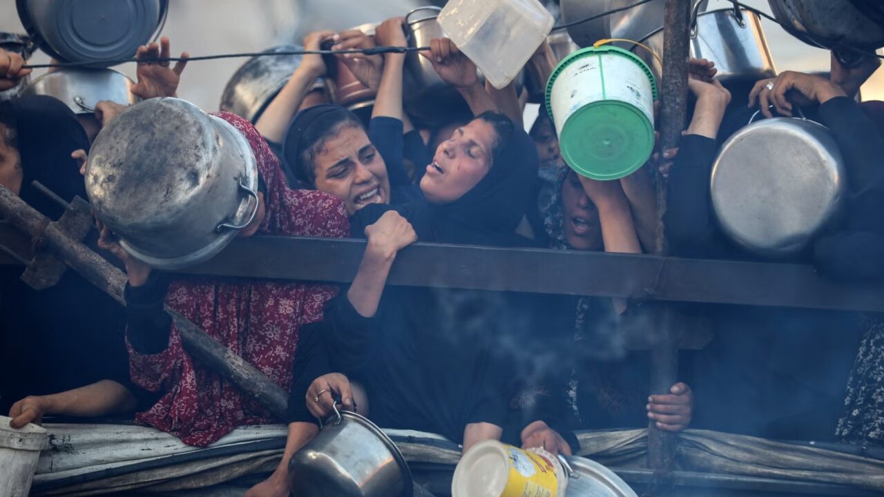 desperate women hold buckets and pots as they try to get food