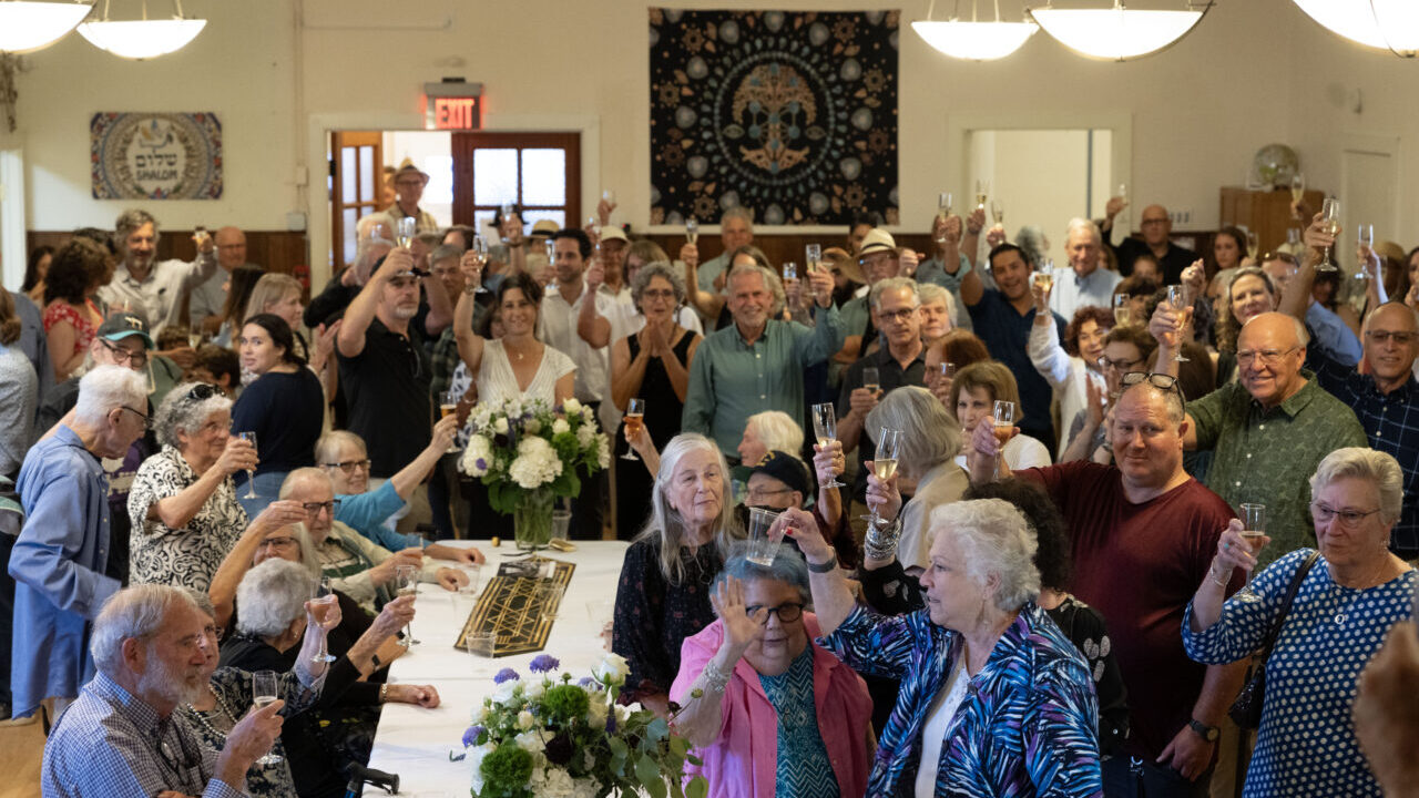 Congregants raise glasses of sparkling wine