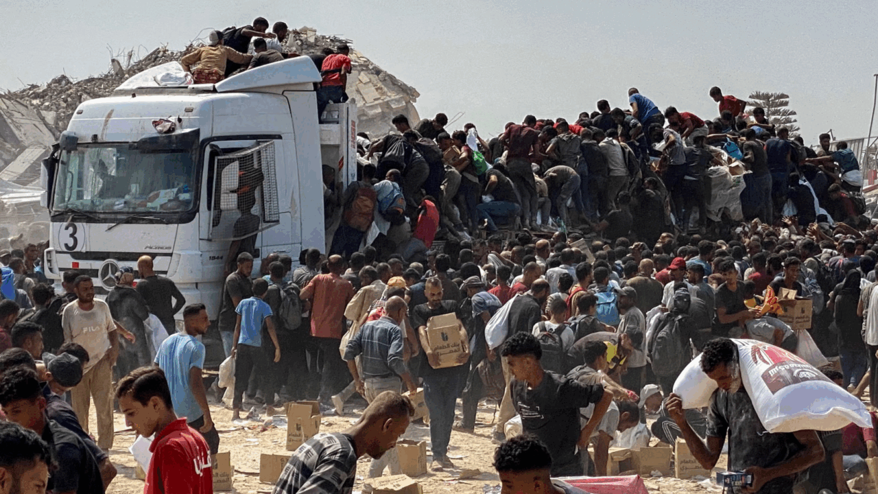 Displaced Palestinians carry food parcels