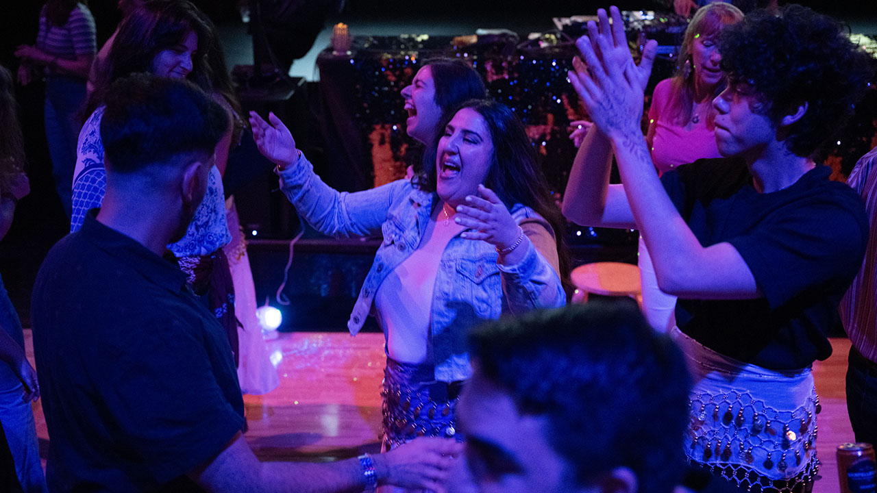 Malka Productions co-founder Danielle Chetrit (center) dances during a Mimouna celebration at the JCCSF in April 2025. (Aaron Levy-Wolins/J. Staff)