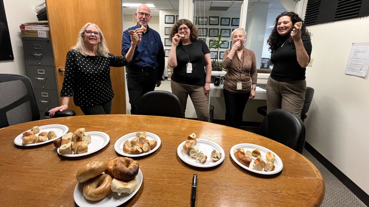 J staff members hold bagels
