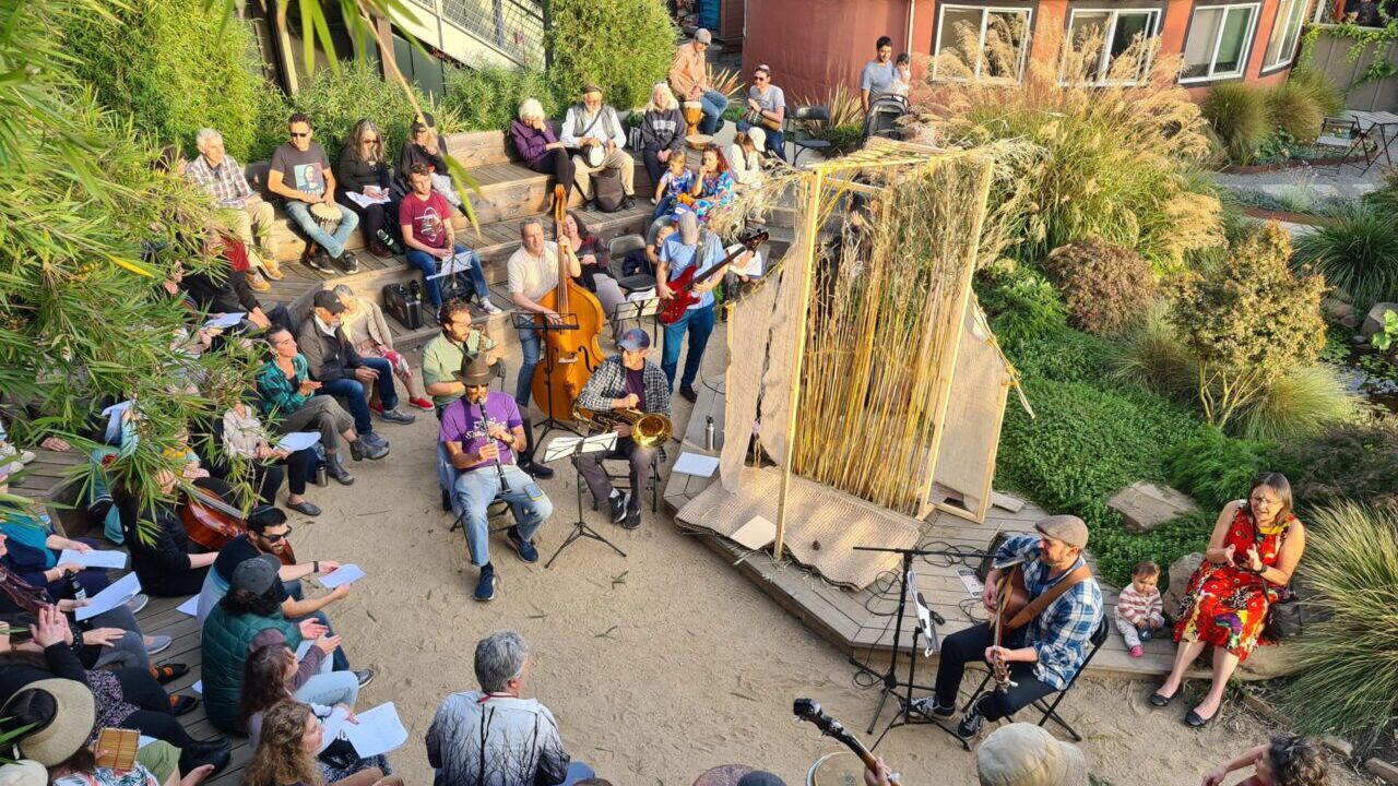 People sing and play instruments outside