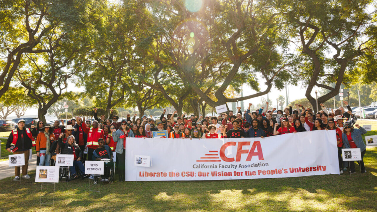 People gather behind a California Faculty Association banner