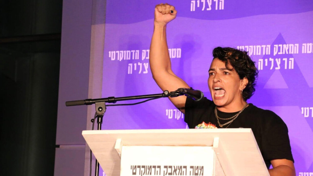 woman at dais raising arm and fist