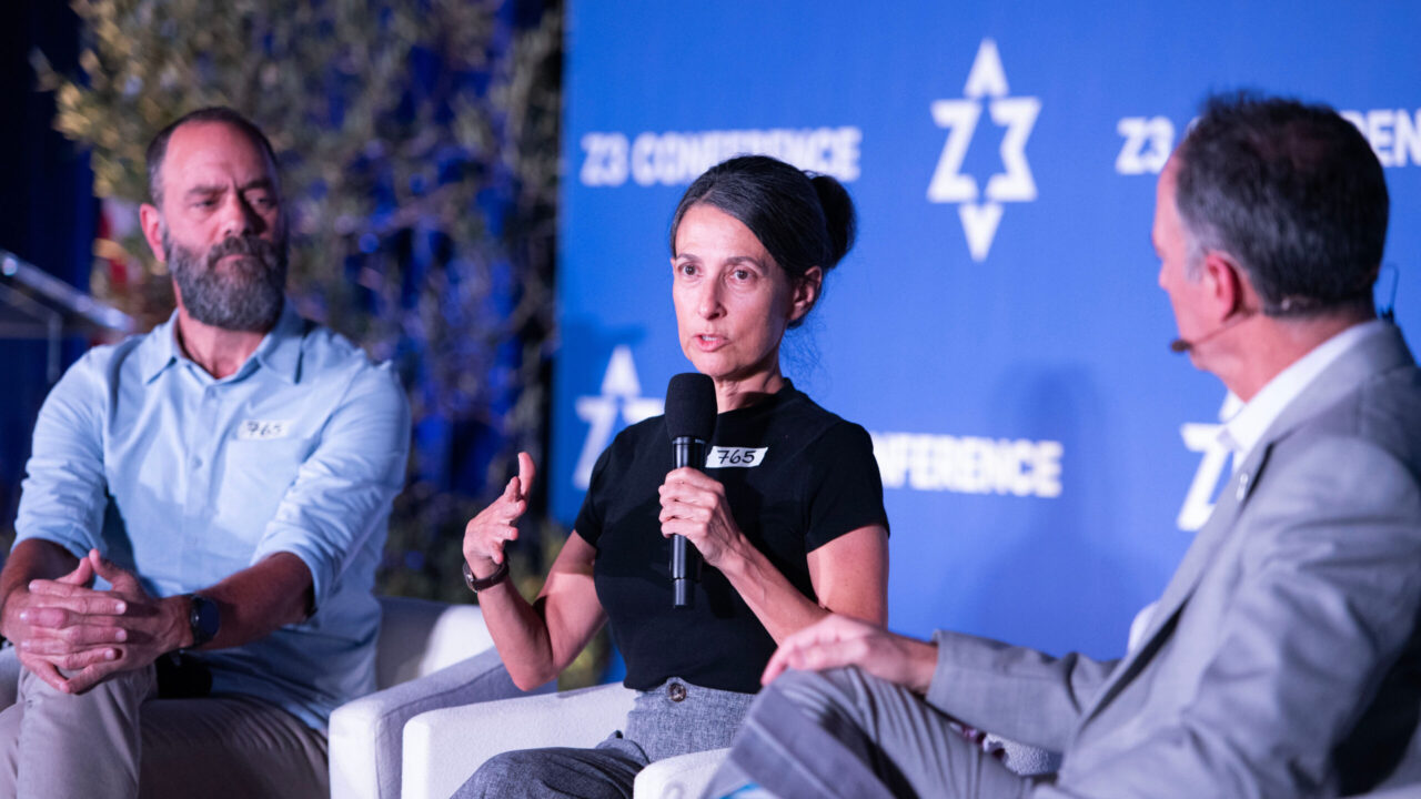 Jon Polin (left) looks on as his wife Rachel Goldberg-Polin talks about the loss of their son, Hersh Goldberg-Polin, to Oshman Family JCC CEO Zack Bodner during the closing plenary of the Z3 Conference at the OFJCC in Palo Alto, Nov. 9, 2025. (Aaron Levy-Wolins/J. Staff)