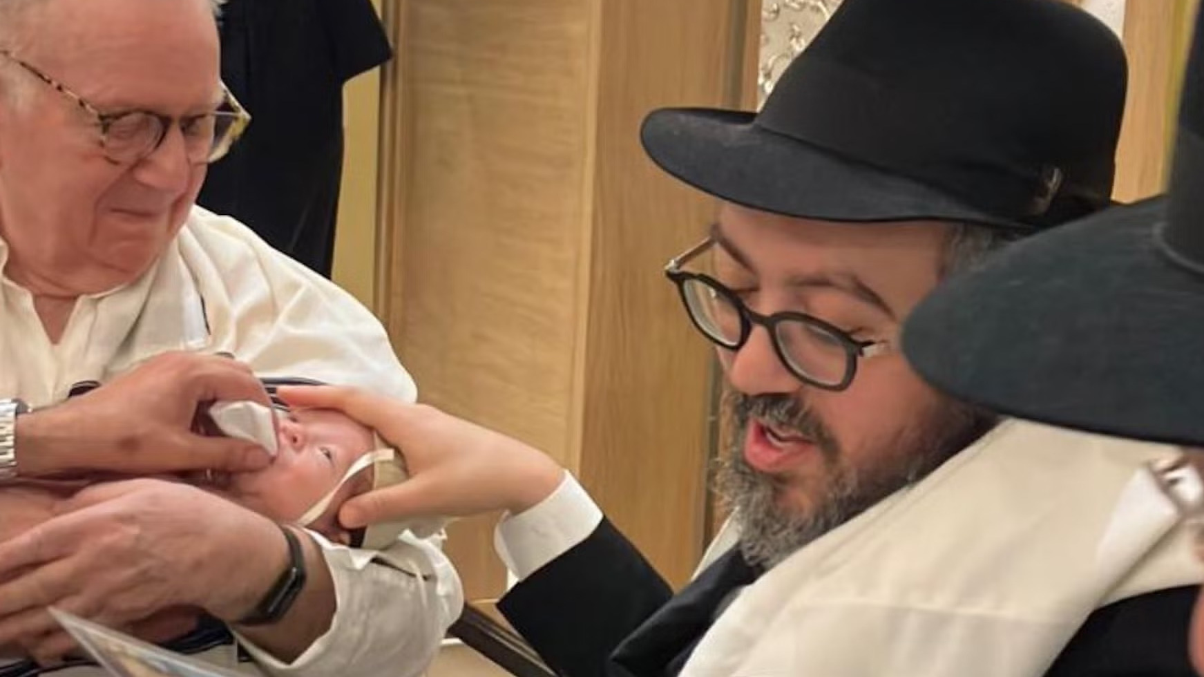 Rabbi Eli Schlanger, at right, participates in his son's bris several weeks before his murder at Bondi Beach on Dec. 14, 2025. (Facebook)