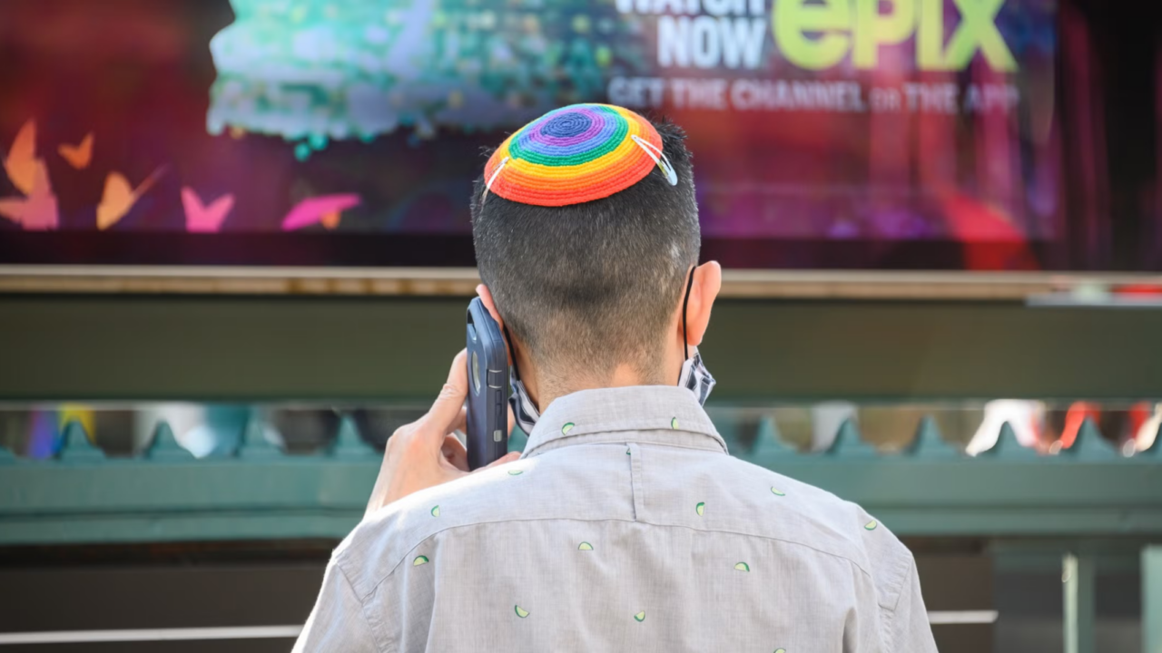 Person wearing rainbow yarmulke