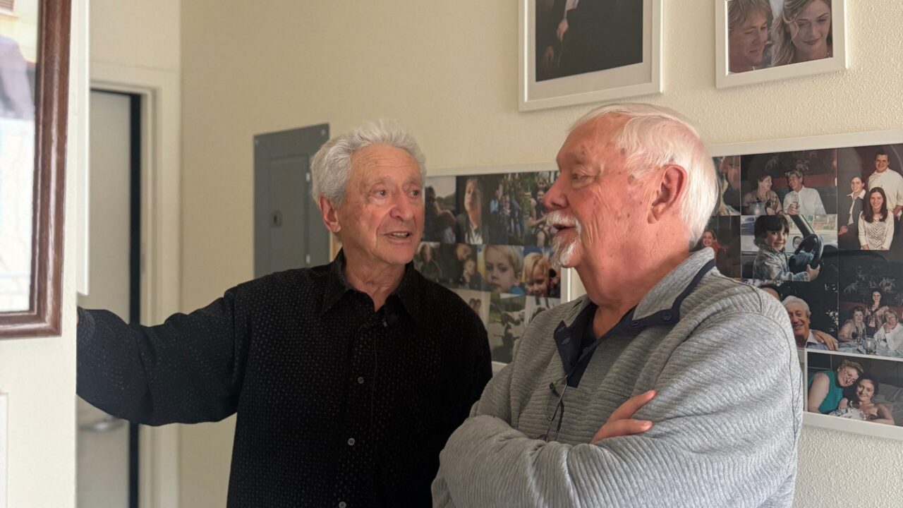 Holocaust survivor Boris Kapilevich (left) shows JFS Silicon Valley board member Harold Hendrickson family photos in his Mountain View home. (Courtesy)