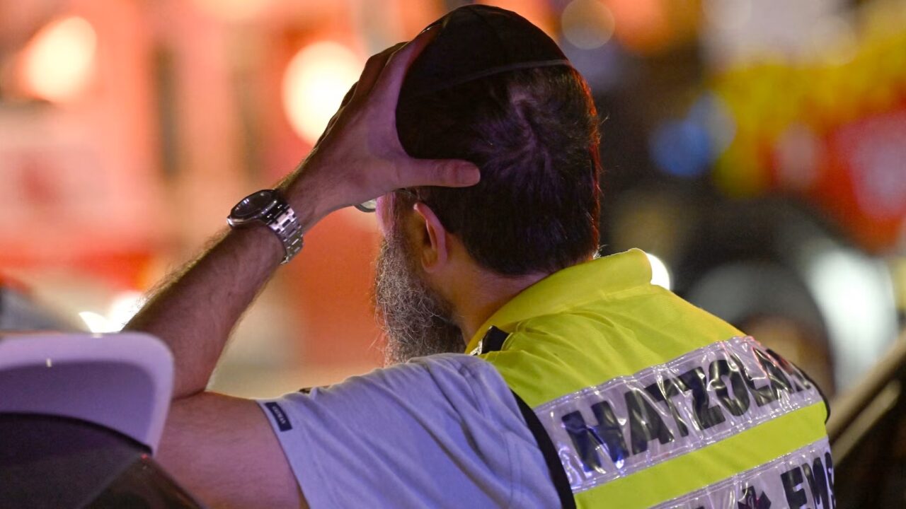 A Jewish first responder reacts as he stands at the site of a shooting incident at Bondi Beach in Sydney on Dec. 14, 2025. (Saeed Khan/AFP)