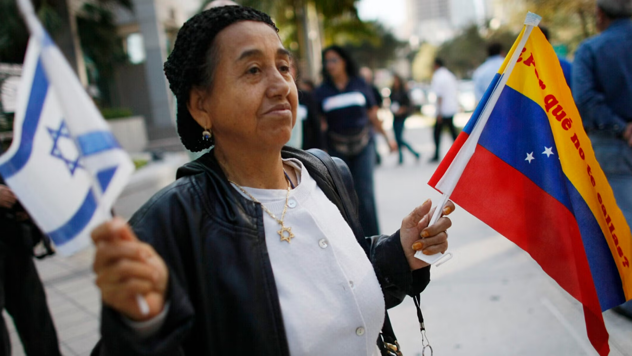 A woman holds Israeli and Venezuelan flags