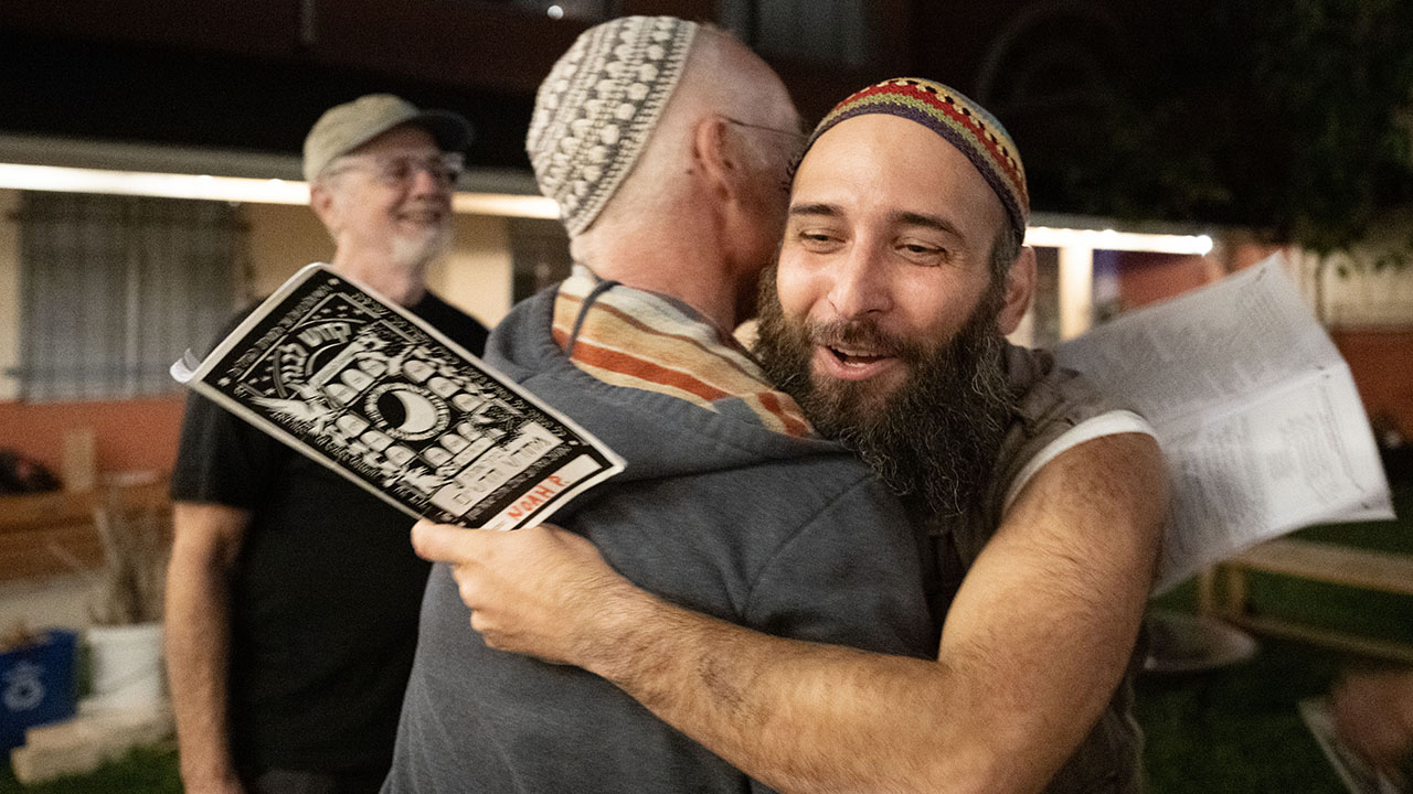 Adam Kinsey hugs Noah Phillips (right) during a Kiddush Levana event at Chochmat HaLev on March 29. (Aaron Levy-Wolins/J. Staff)