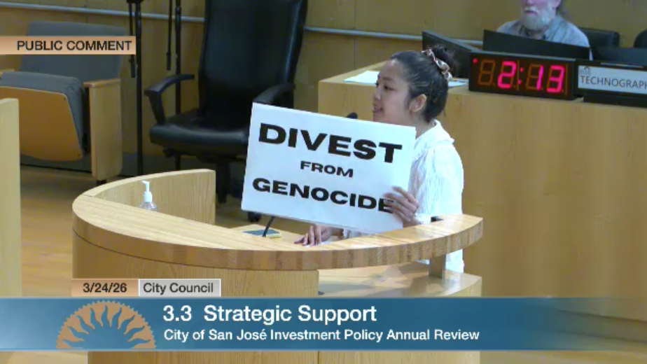 Woman holds sign saying divest from genocide