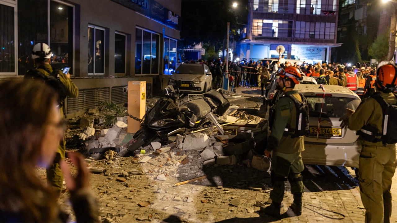 First responders work at the site of a building hit by an Iranian missile strike in Ramat Gan, on the outskirts of Tel Aviv, early on March 18, 2026. (Ilia Yefimovich / AFP via Getty Images)