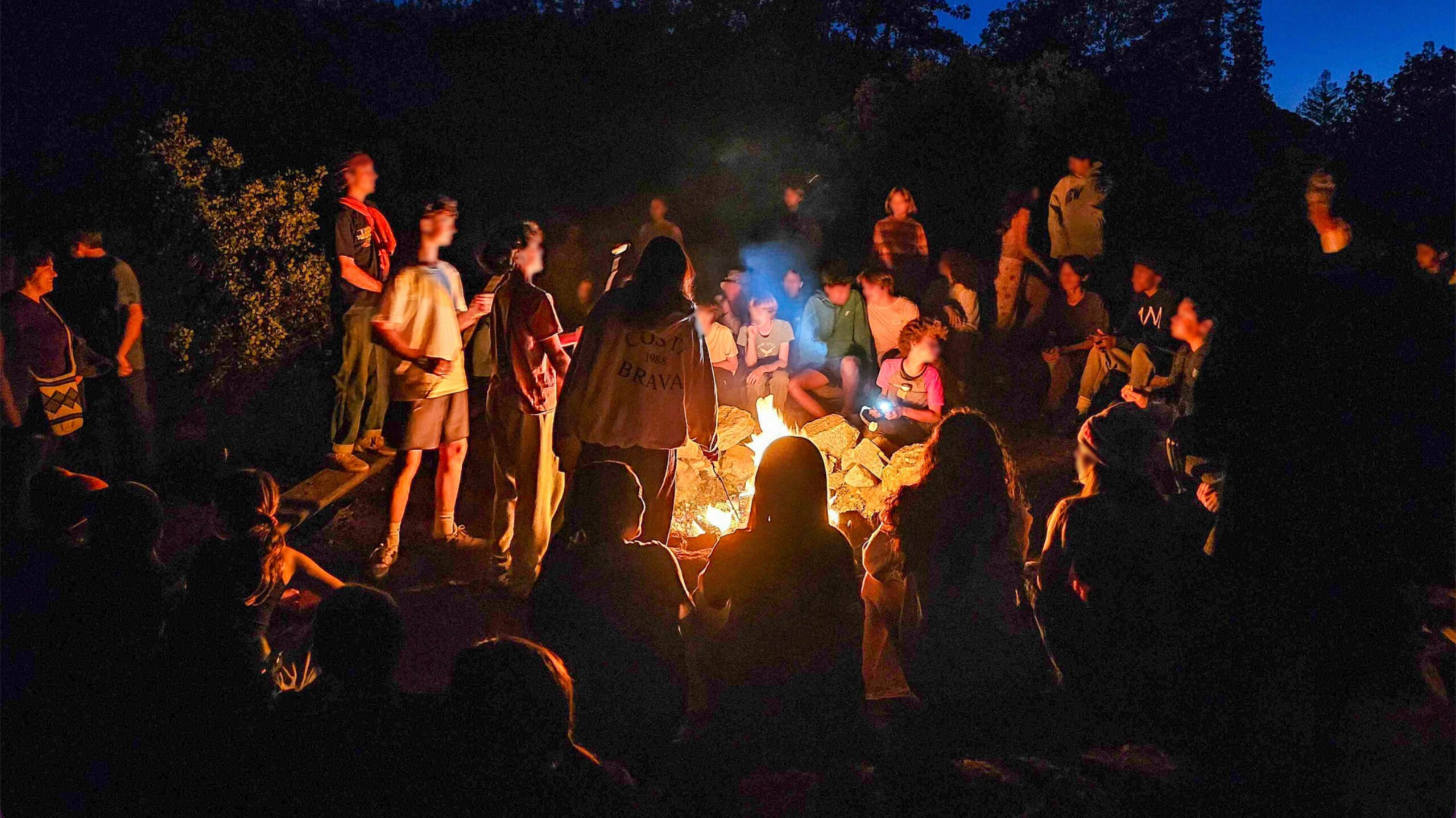 Prospect Sierra students sit around a campfire at Camp Tawonga. (Prospect Sierra/Facebook)