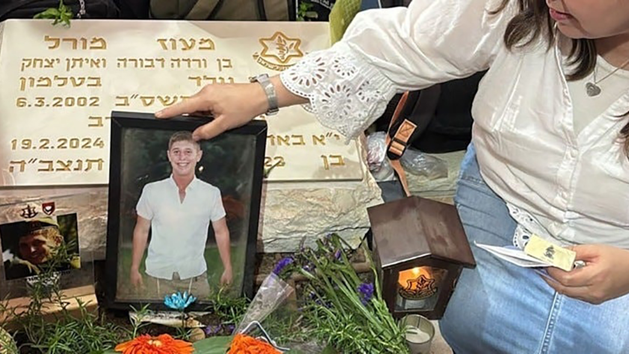 Varda Morrell lays a photo at the gravesite of her son, Israeli Staff Sgt. Maoz Morell, in 2025. (Courtesy Varda Morell)