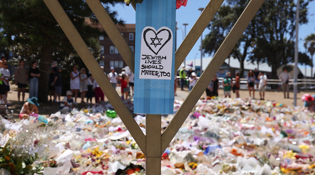 A sign reading "Jewish Lives Should Matter, Too" is seen at the floral tributes area outside Bondi Pavilion in Sydney on Dec. 18, 2025, to honor victims of the Bondi Beach shooting. (David Gray/AFP via Getty Images)