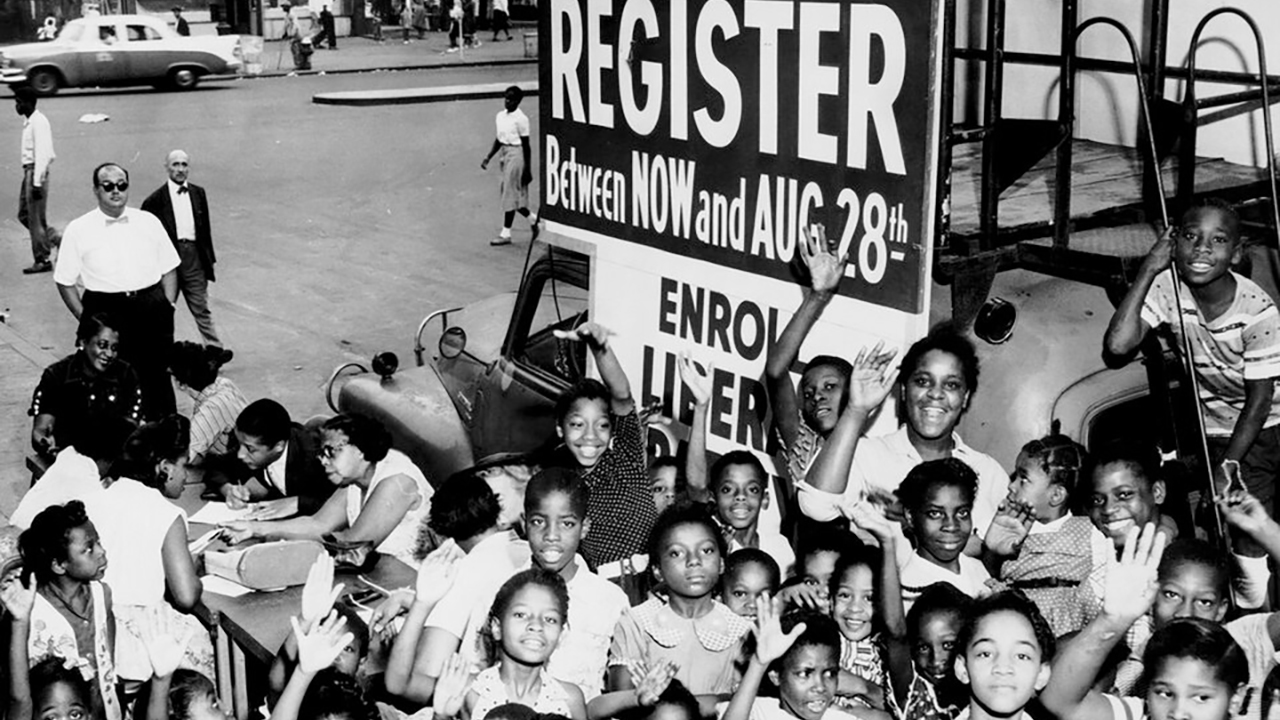 A large group of African American children gather around a voter registration booth in the early 1960s. (Kheel Center, Cornell University Library via Flickr CC BY 2.0)
