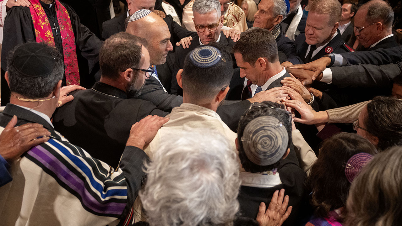 Clergy members of various faiths put their hands on Mayor-Elect Daniel Lurie for a communal blessing during an interfaith celebration for Lurie at Congregation Emanu-El in San Francisco on Jan. 7, 2025. The photo was honored in the 2026 California Journalism Awards. (Aaron Levy-Wolins/J. Staff)