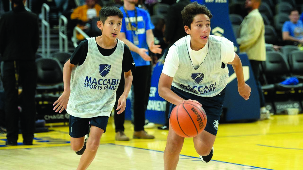 Maccabi Sports Camp campers playing against the Brandeis School of Marin in a basketball game at halftime during the Golden State Warriors’ Jewish Heritage Night in San Francisco, December 2024. (Aaron Levy-Wolins/J. Staff)
