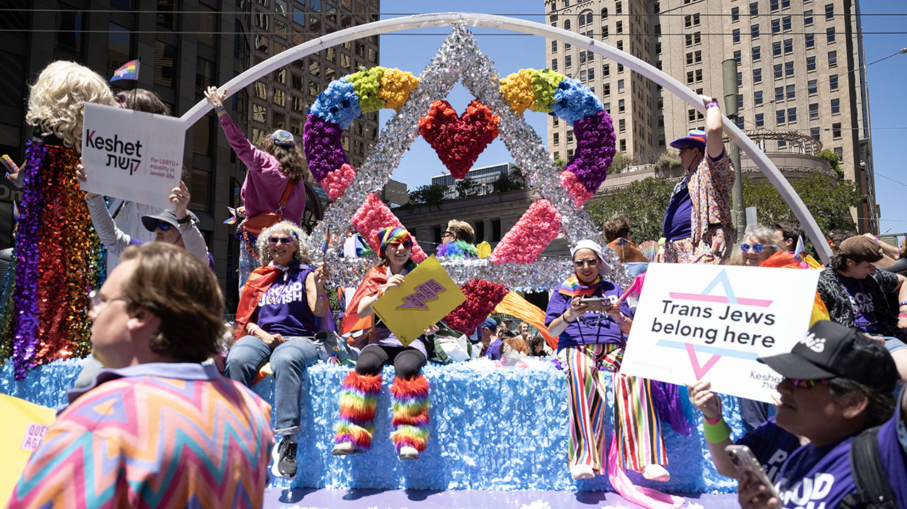 Proud & Jewish marchers hold signs in support of transgender Jews while riding on a float during the San Francisco Pride parade on June 28. (Aaron Levy-Wolins/J. Staff)