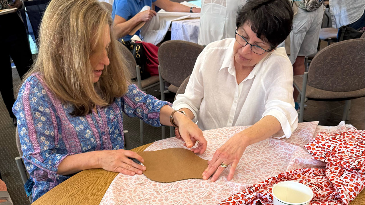 Catherine Crystal Foster (left) and Karen Kronick trace a sanitary pad template during Congregation Beth Am's Mitzvah Day in March. (Todd Kaye)