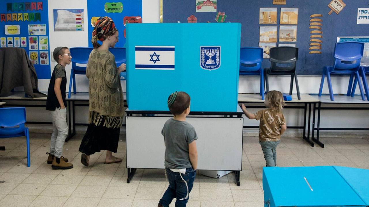 An Israeli woman casts her vote as her children join her during Israel's general elections in Har Homa, in eastern Jerusalem, Nov. 1, 2022. (Amir Levy/Getty Images)