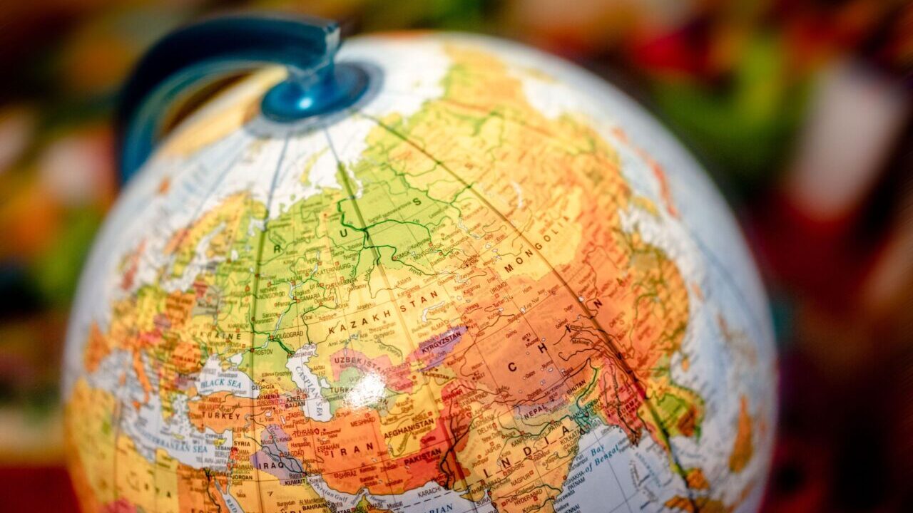 Vibrant close-up of a globe displaying the Eurasian continent, featuring countries like China and Russia.